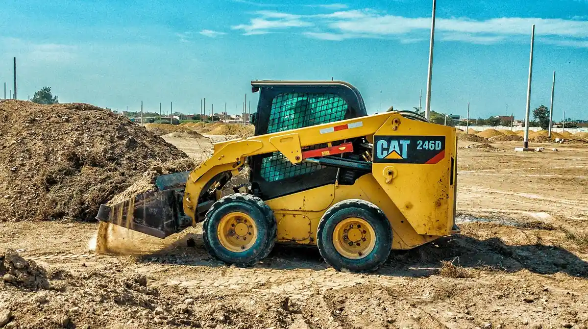 Loader Bushing Contamination A loader working in a muddy, dusty environment, highlighting the harsh conditions.